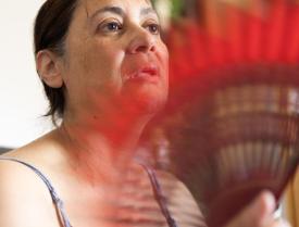 Woman fanning herself with a handheld fan