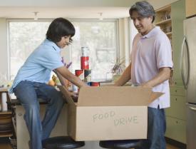 People reaching into a box labelled food drive