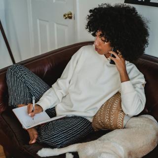 mujer en sillón con teléfono